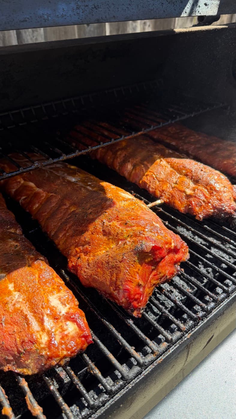 A rack of Miggy's Piggies ribs on the smoker